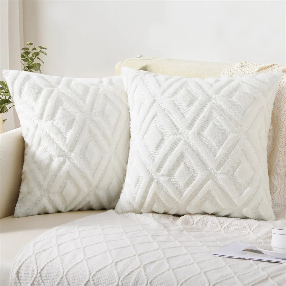 Two textured white pillows on a beige sofa with a light background