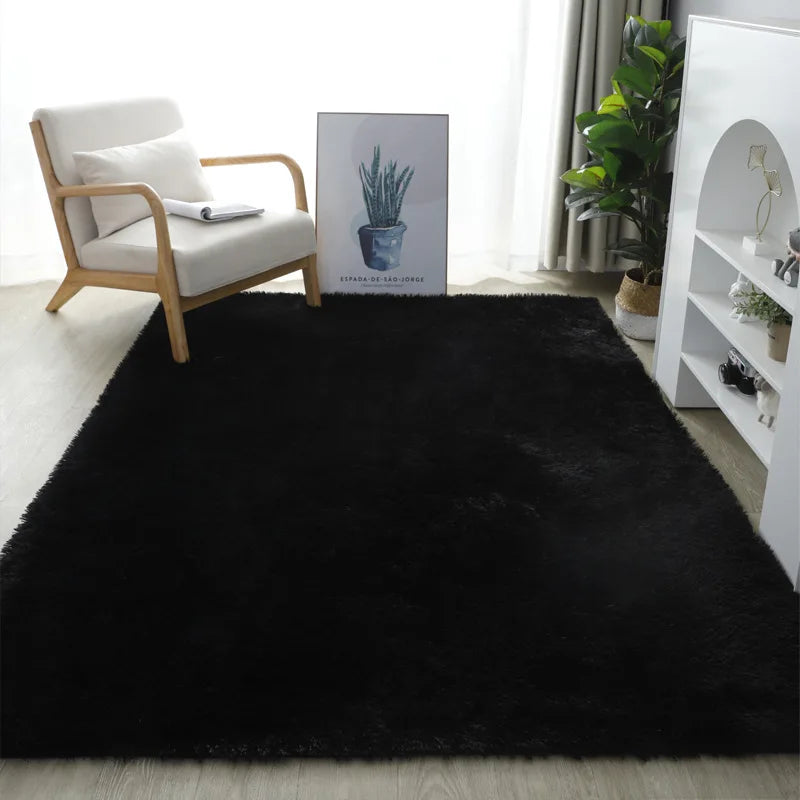 Black rug in a living room with a chair and decor items.