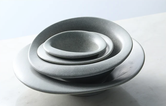 Set of gray ceramic bowls stacked on a light background